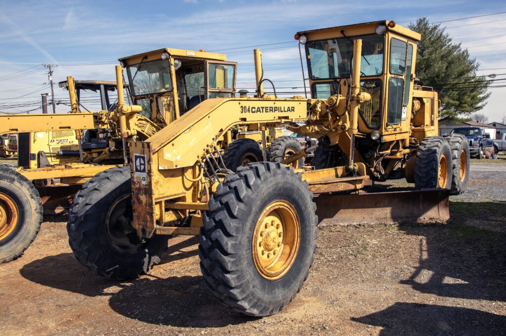Caterpillar 12G motor grader parked in an equipment yard