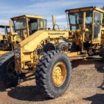 Caterpillar 12G motor grader parked in an equipment yard