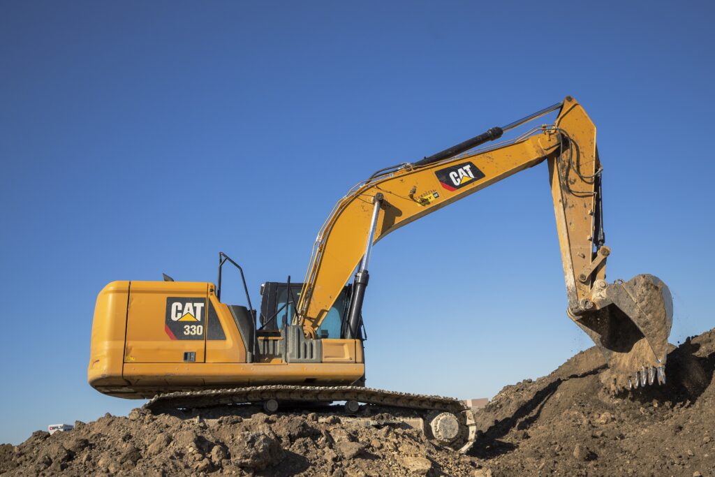 Caterpillar 330 excavator working on a pile of dirt