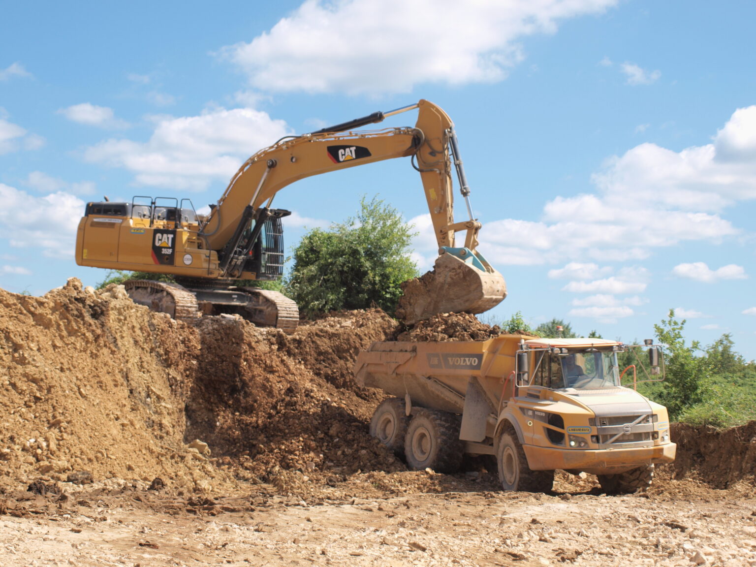 Caterpillar 352F excavator loading an articulated dump truck