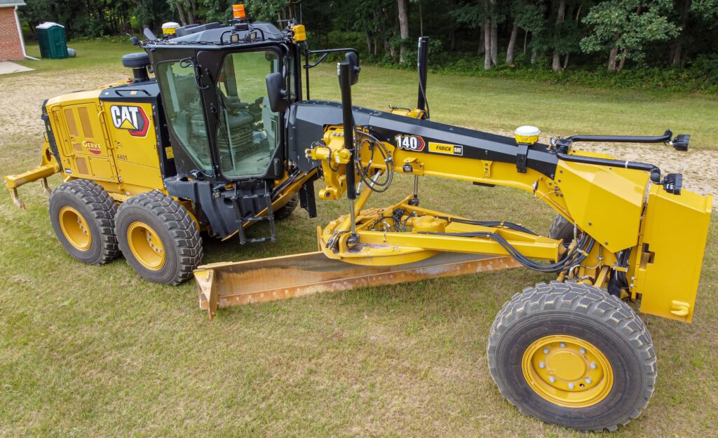 Caterpillar motor grader with moldboard and front push blade
