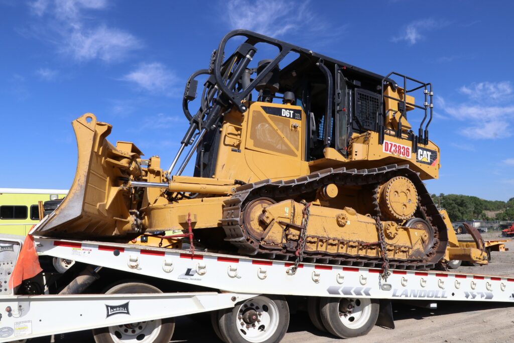 Crawler dozer secured on a lowboy trailer for heavy haul shipping
