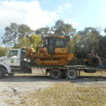 John Deere 650J dozer loaded on a ramp truck